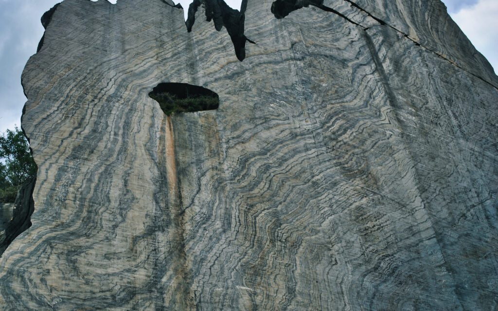 Este afloramento na Serra do Cipó, em Minas Gerais, é uma notável pedreira. Representa uma das raras dobras em bainha encontradas no Brasil e foi recentemente limpa pela SGB. A Serra do Cipó é um destino turístico natural de grande importância, conhecido por suas trilhas, cachoeiras e pela preservação ambiental.